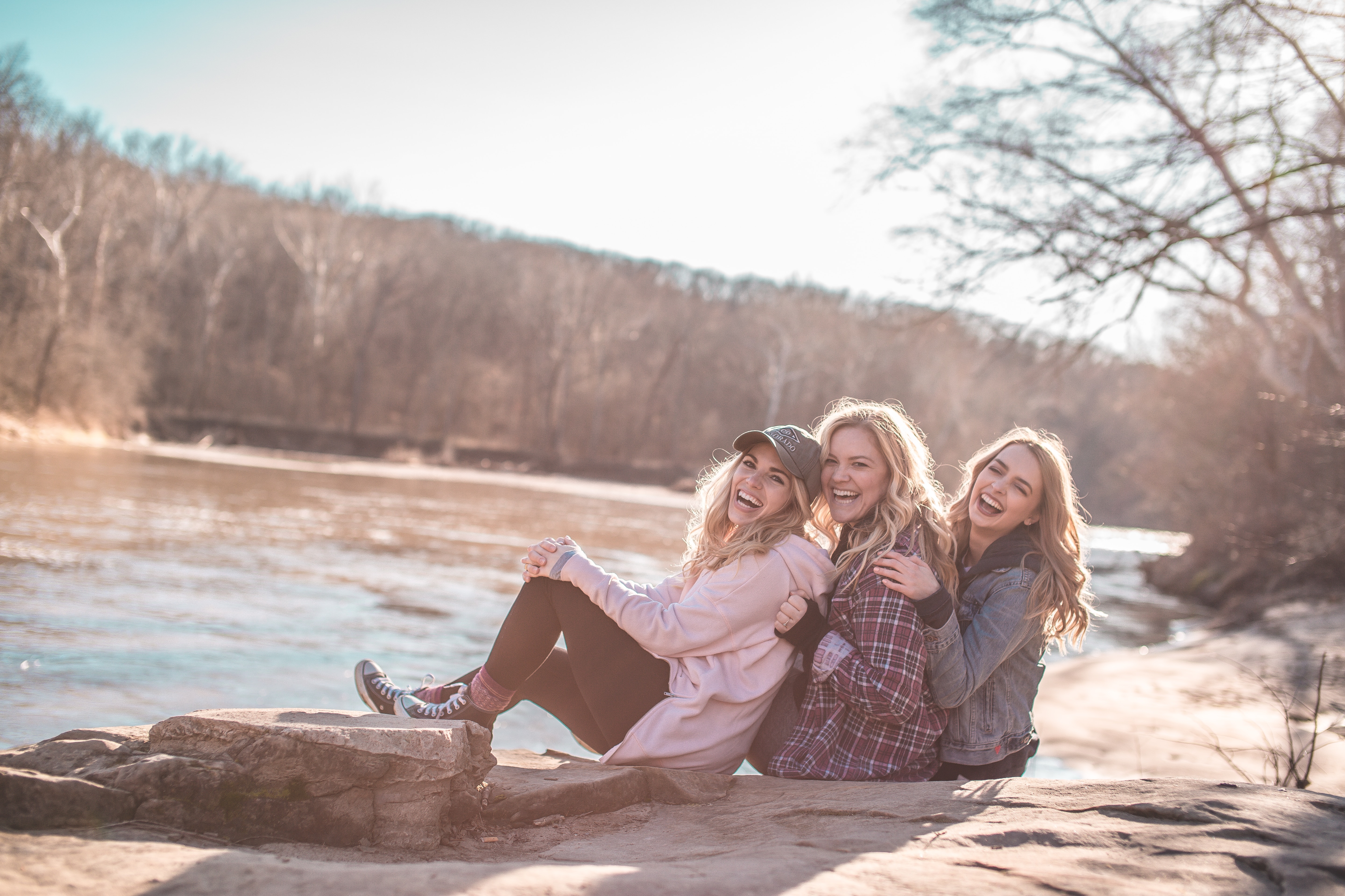 三個好朋友開心坐在溪邊感受生活的美好