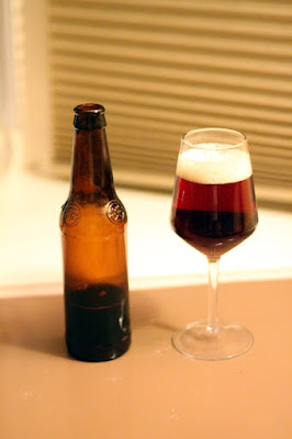 A wine glass of sour beer brewed with buckwheat and flavored with pie cherries.