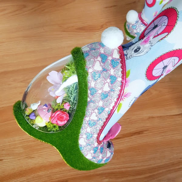 side view of magical garden heels with toadstool house and bunny figure inside