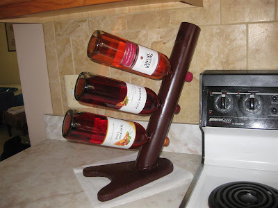 simple homemade wine rack, PVC pipe, wood, wine bottles