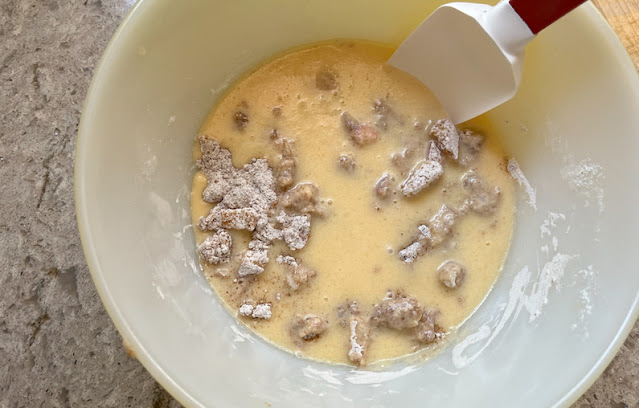 The dry ingredients in a mixing bowl, with the wet ingredients on top