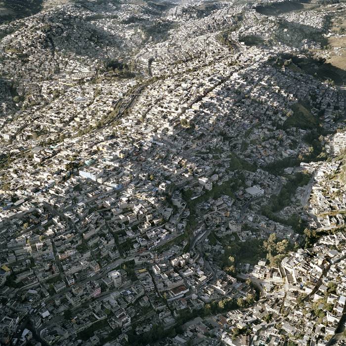 Unbelievable aerial photographs of Mexico City show how the urban landscape spreads over mountains while maintaining a remarkable 25,400 people per square mile. 