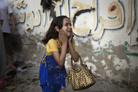 A Palestinian girl reacts at the scene of an explosion that medics said killed eight children and two adults, and wounded 40 others at a public garden in Gaza City, July 28, 2014.  REUTERS/Finbarr O'Reilly