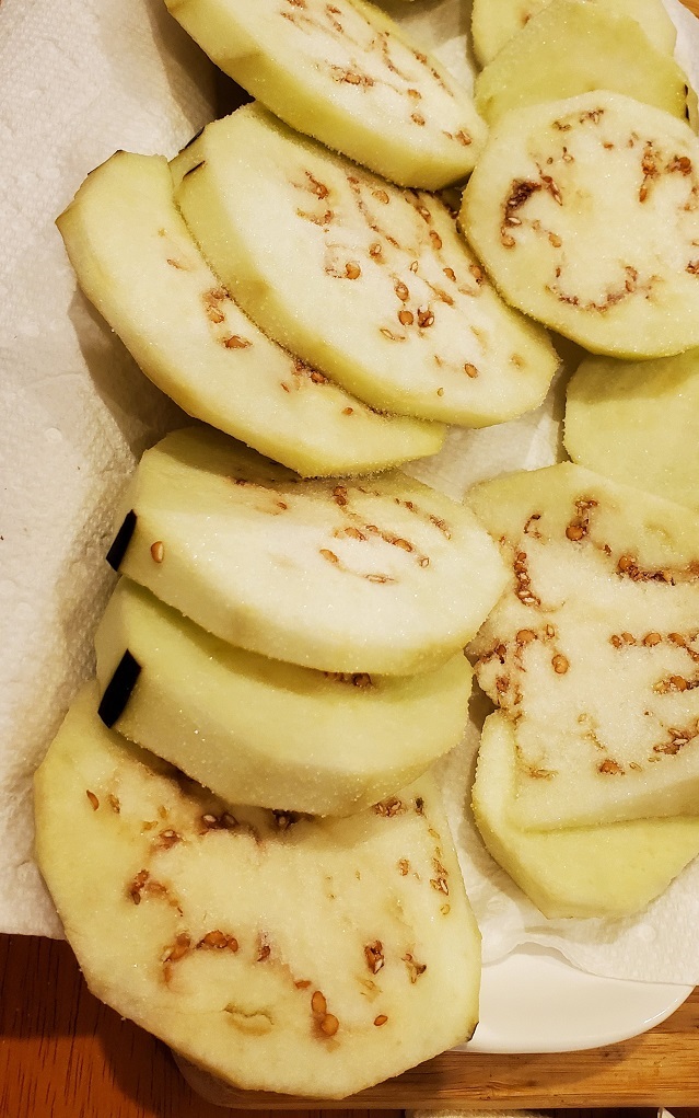 sliced eggplants draining on paper towels