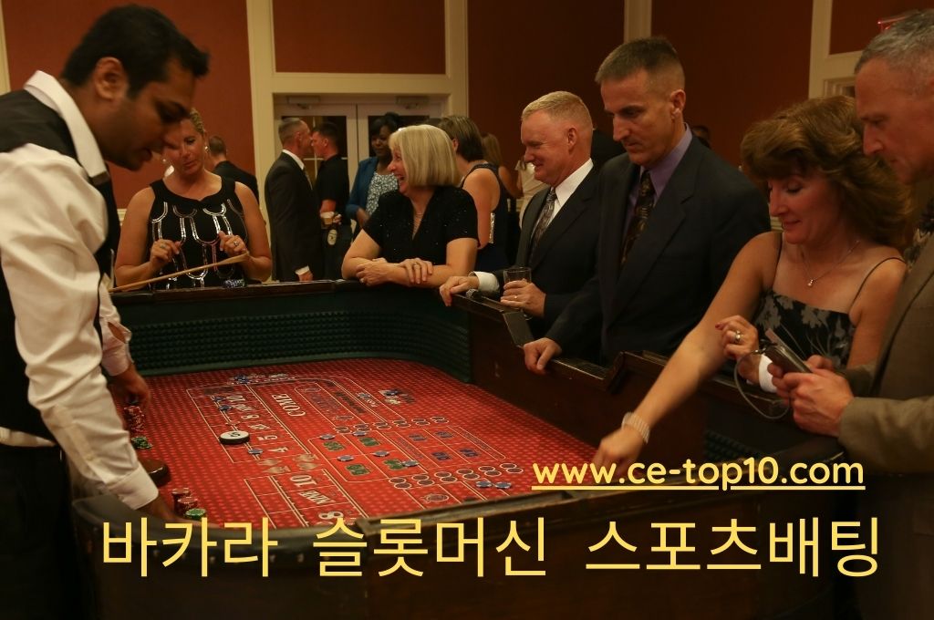 Group of gamblers inside casino are playing craps while casino dealer assisted them