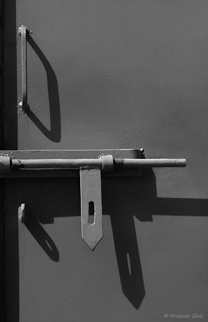A Minimal Art Photo of Long Shadows of the Handles of a Metal Door in Black and White