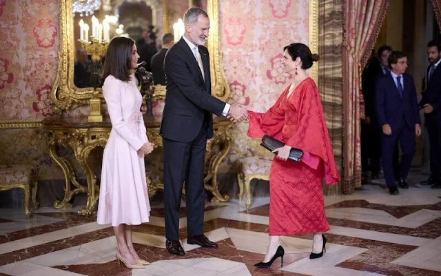 Queen Letizia wore a midi dress by Pedro del Hierro. President Isabel Díaz Ayuso wore a red silk cape style midi dress