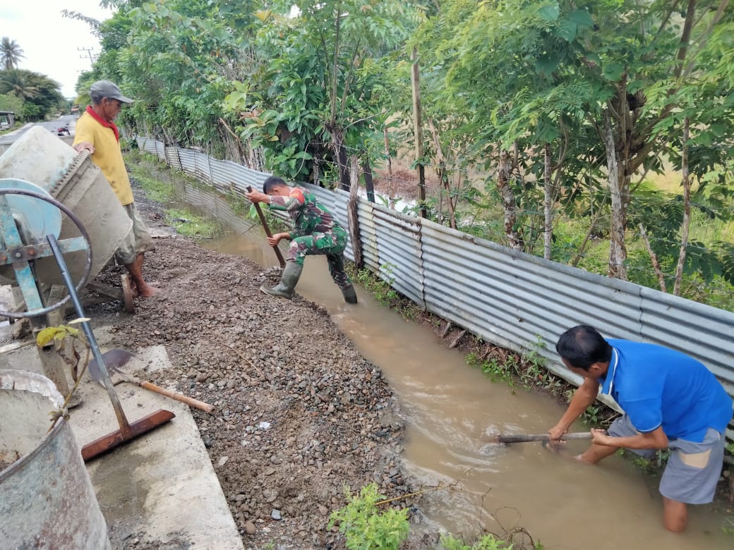 Foto : Serda Liyana Supriyatna membantu warga masyarakat menggali parit yang tersumbat, Kamis (22/9/2022).