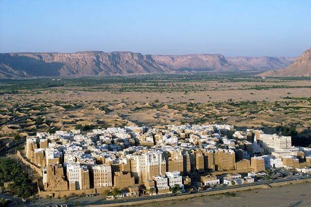 The city of Shibam, located in the central-western area of Hadhramaut Governorate, in the Ramlat al-Sab`atayn desert, is best known for its towering mudbrick skyscrapers. This small town of 7000 is packed with around 500 mud houses standing between 5 and 11 stories tall and reaching 100 feet high, all constructed entirely of mud bricks. The bizarre skyline that the high rise buildings bestow upon the city has earned Shibam the moniker "Manhattan of the Desert."