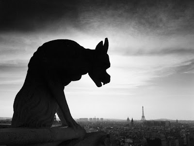 Black and white wall mural of a Gargoyle's silhouette atop Notre Dame 