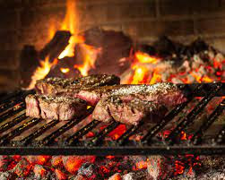A close-up of juicy meat on a grill, with flames visible in the background, and a skewer of meat being broiled in an oven.