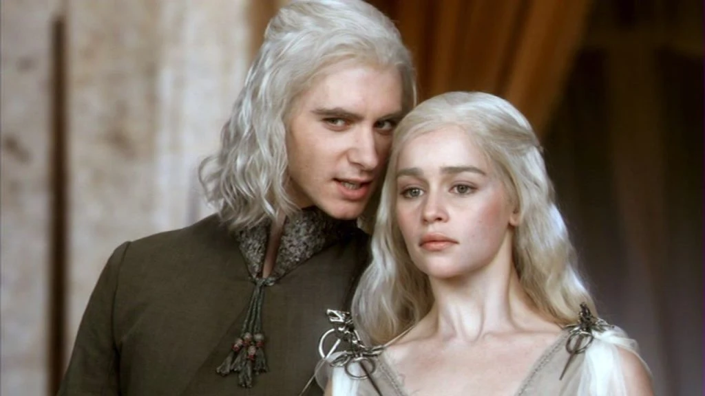 A promotional image featuring actors portraying King Viserys I and Rhaenyra Targaryen, standing against a regal backdrop