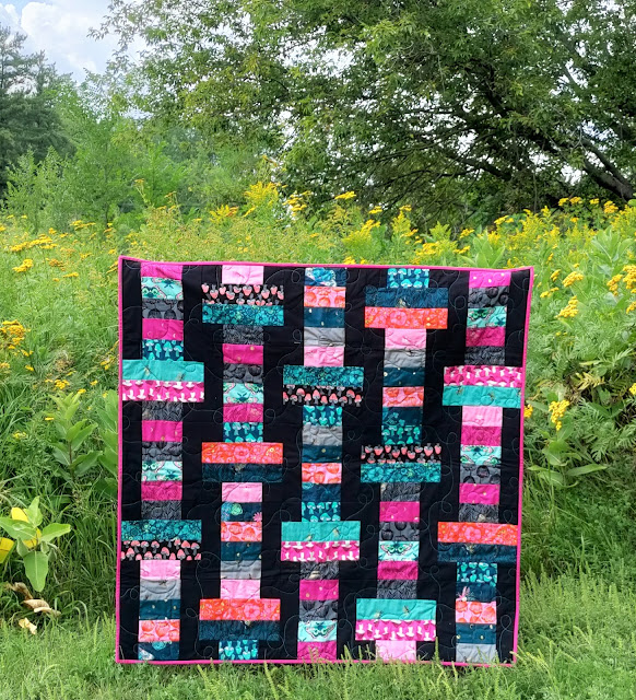 The Firefly collection sewn into a lap quilt using the Slice jelly roll pattern from Fat Quarter Shop