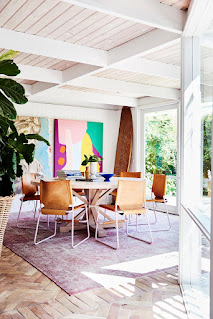 round dining table with cognac brown leather dining chairs, terracotta roofing tiles repurposed for the floor