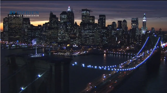 Photo of Lower Manhattan at sunset as seen from above the Brooklyn Bridge