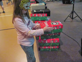 Little girl with Operation Christmas Child shoeboxes at packing party.