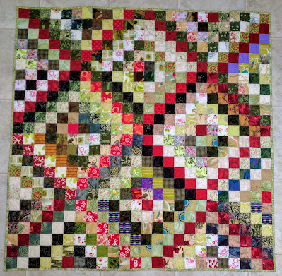 Scrappy Trip Around the World quilt in greens with red diagonals