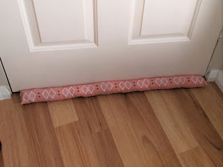 A closed door from the other side, also with a pink fabric snake.