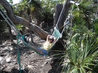 Julie laying in a hammock made from old fish nets found washed up on the shore