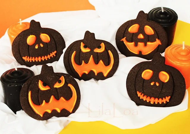 Decorated chocolate sugar cookies that look like glowing Jack-O-Lanterns