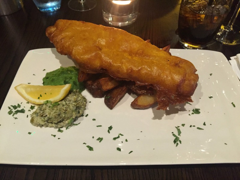 Fish and chips with a side of tartare sauce and mushy peas