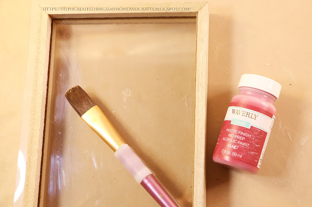 Paintbrush, frame décor, and paint on table