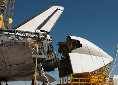 Technicians attach a cover over Discovery's engines