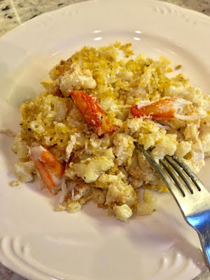 Photo of homemade macaroni and cheese with fresh crab on a white plate