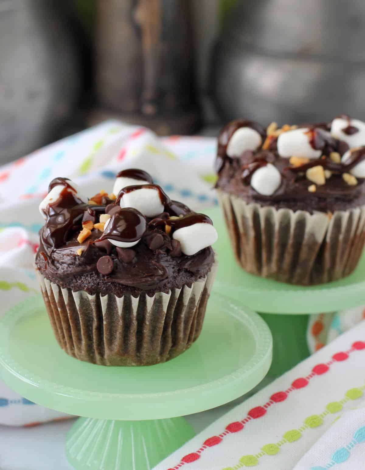Two Rocky Road Cupcakes on green cupcake stands.