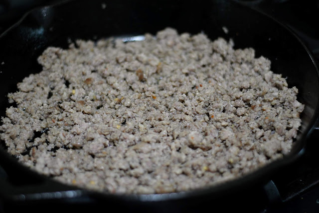 The fully cooked breakfast sausage in a cast iron skillet.