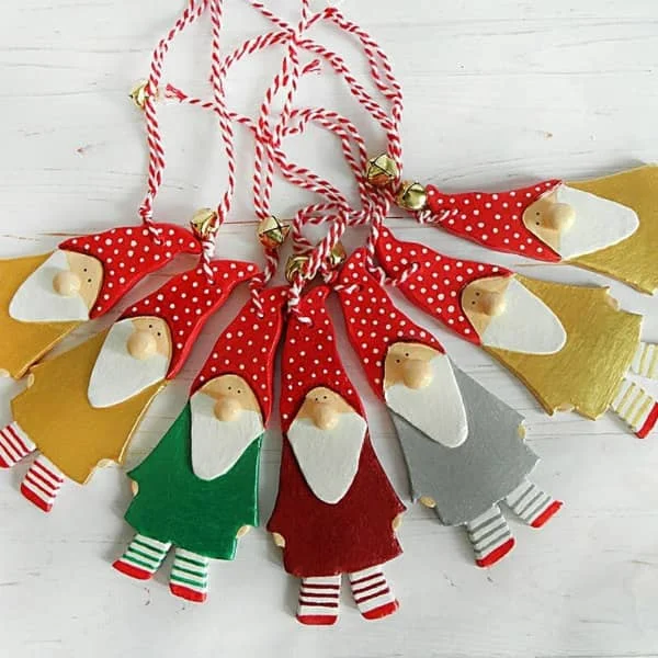 paper mache gnome ornaments with red and white striped hanging cords displayed on flat surface