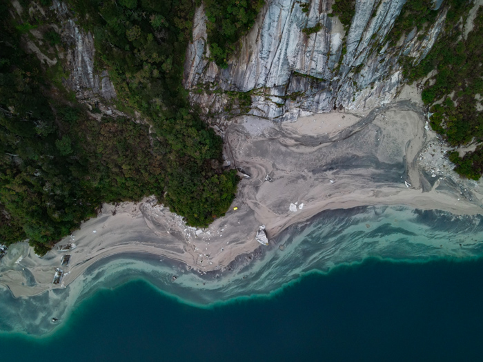 The picture shows the beach and the lake from top. The picture was taken with a drone.