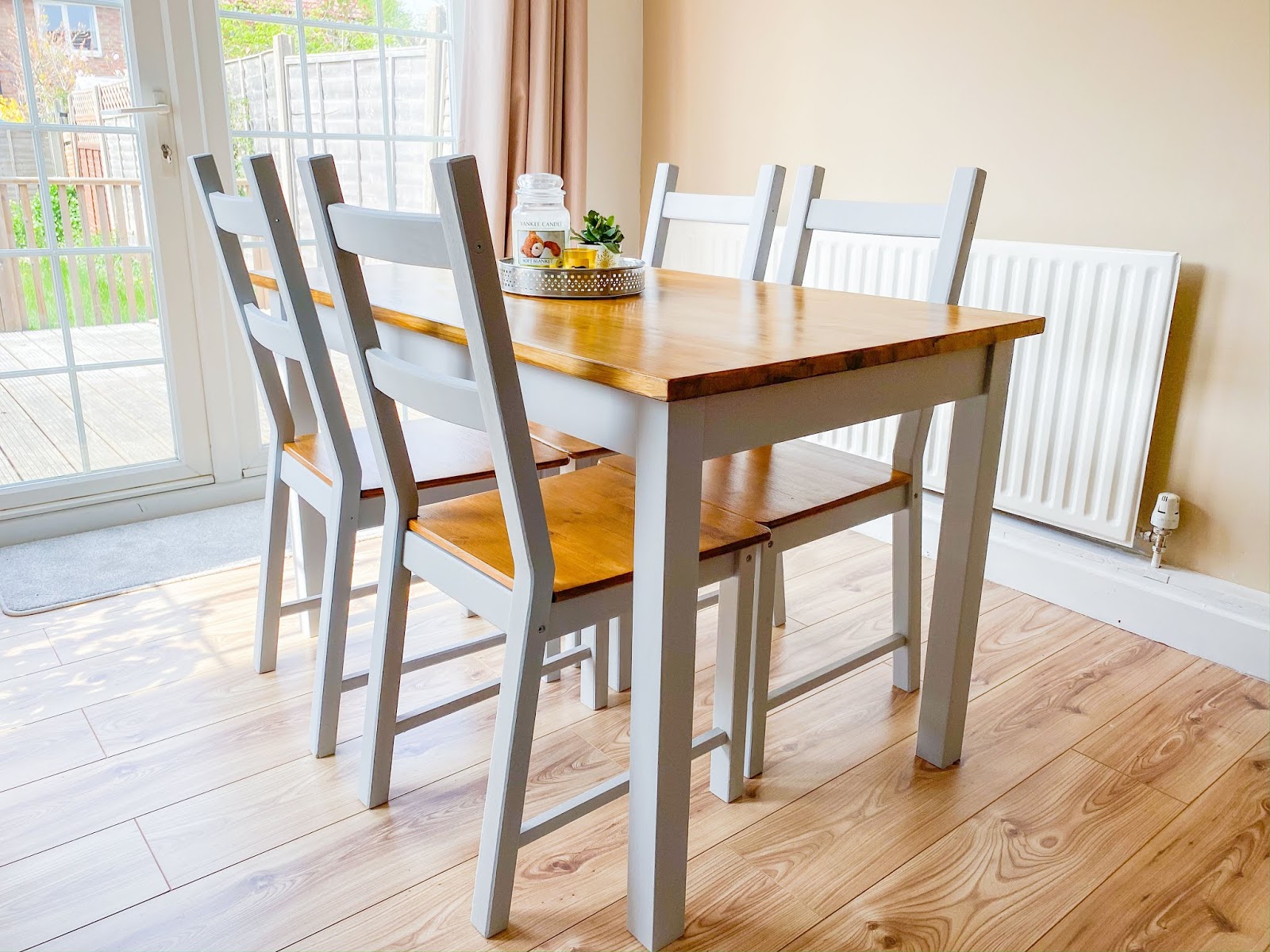 A farmhouse style grey and oak dining table and chairs