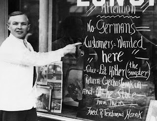 Prague-born restaurant owner Fred Horak of Somerville, MA putting up a sign barring German customers from entering his property until Hitler the Gangster returns the lands he seized from Czechoslovakia