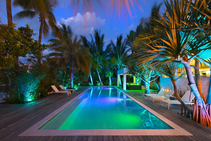 Large swimming pool in Modern mansion in Miami at night