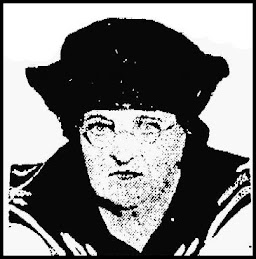 A poor-quality picture of a middle-aged white woman wearing a sailor-style dark hat and blouse. She has small facial features and is wearing small wire-rimmed eyeglasses.