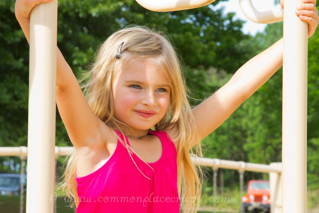 Smiling little girl on playground equipment