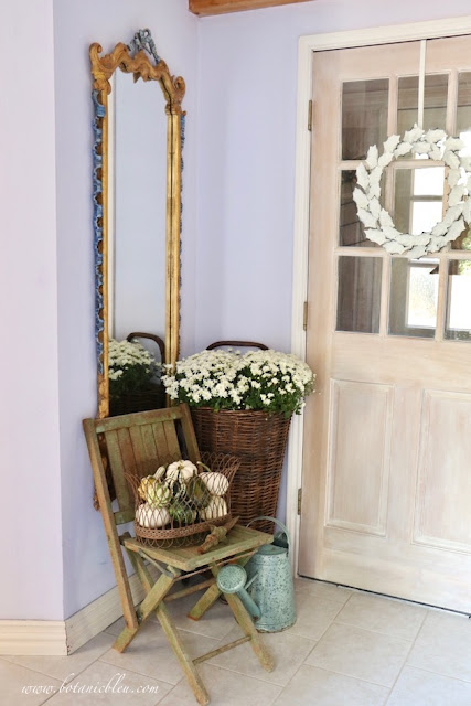 French Country rustic fall entry with elegant French mirror juxtaposed against a rustic wooden folding chair