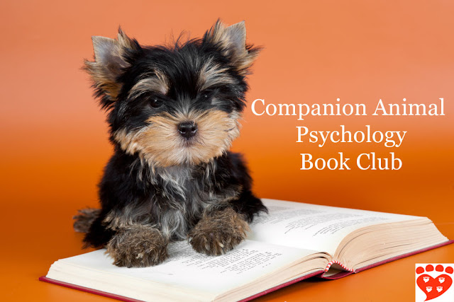 A puppy reads a book for the animal book club