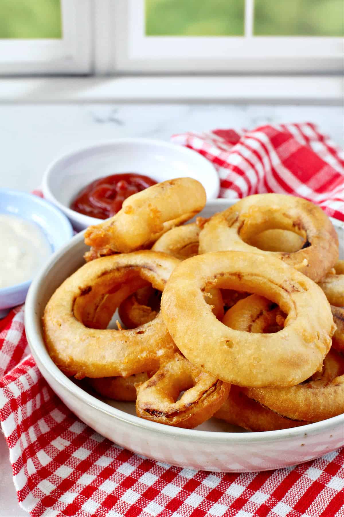 Three-Ingredient Sourdough Onion Rings with two dipping sauces.