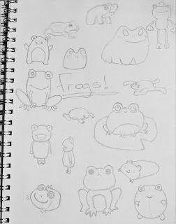 Sketch book with "frogs" written in the middle with pencil drawings of different frog designs
