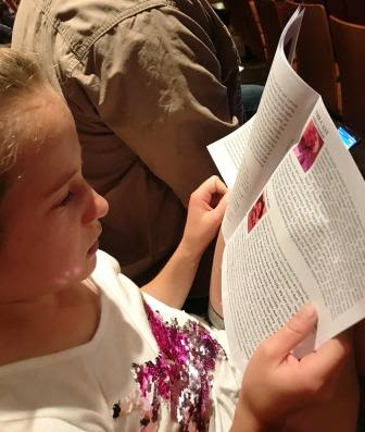 Girl looking at Beauty and the Beast JR programme at Peoples Theatre