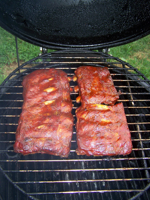 Two slabs of cooked ribs on a Bubba keg