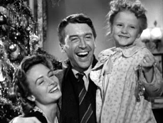 George Bailey (James Stewart), Mary Bailey (Donna Reed), and their youngest daughter Zuzu (Karolyn Grimes) in Frank Capra’s 1946 It’s a Wonderful Life.