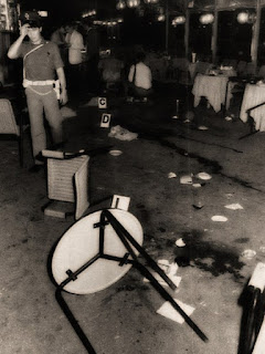 A bloodstained pavement and upturned tables and chairs after the attack