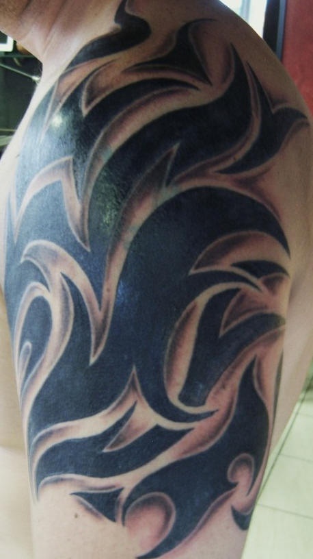 Black ink tribal tattoo on shoulder