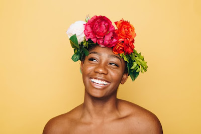 Laughing African lady wearing rose on the head