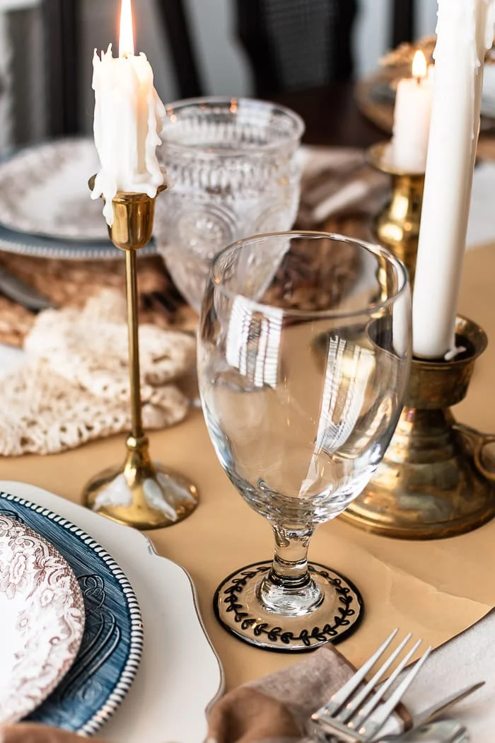 brass candlesticks, water goblet, coffee stained doily