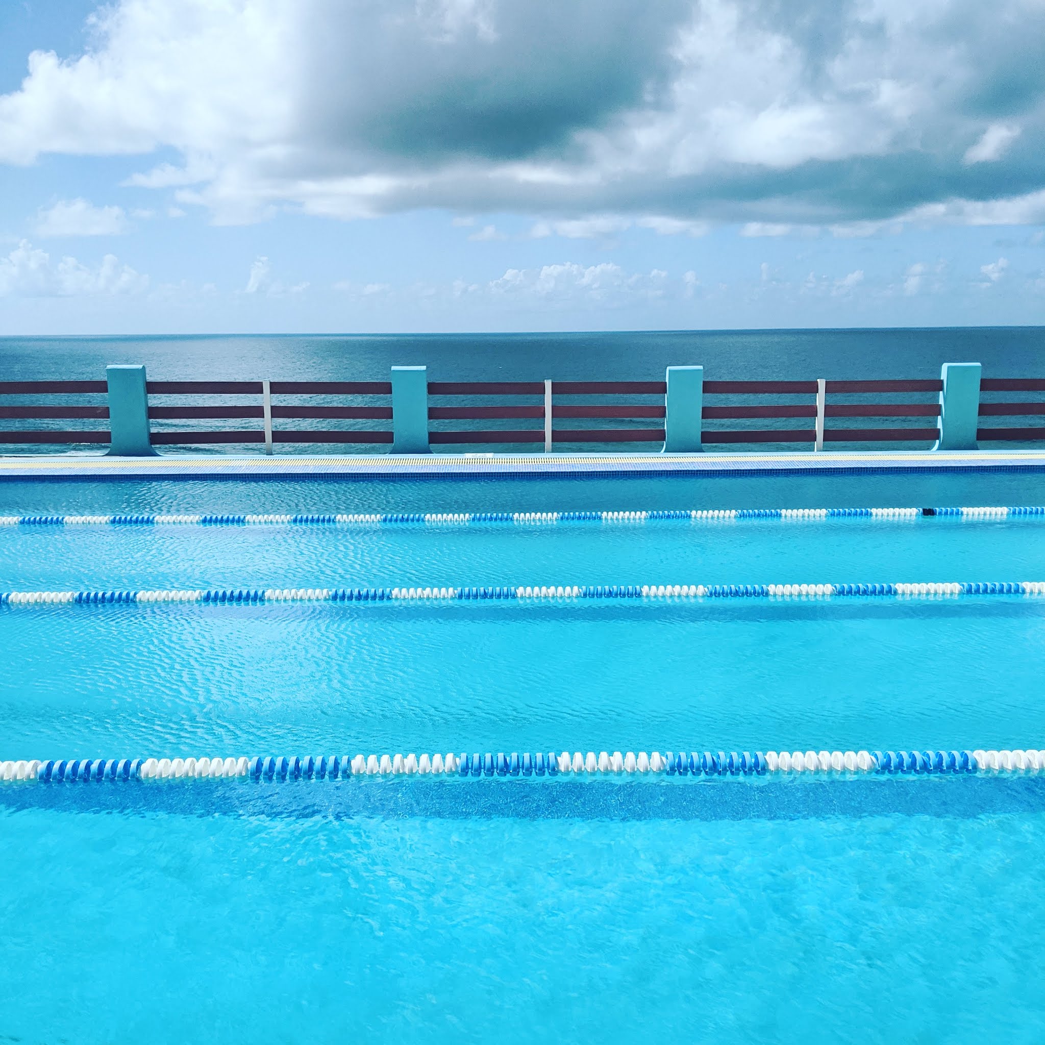 A bright blue swimming pool overlooking the ocean on the north coast of Barbados. On this stretch of coast sit some of the most beautiful beaches in Barbados