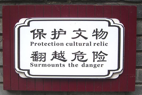 a sign with Chinese characters and then "Protection cultural relic | Surmounts the danger"